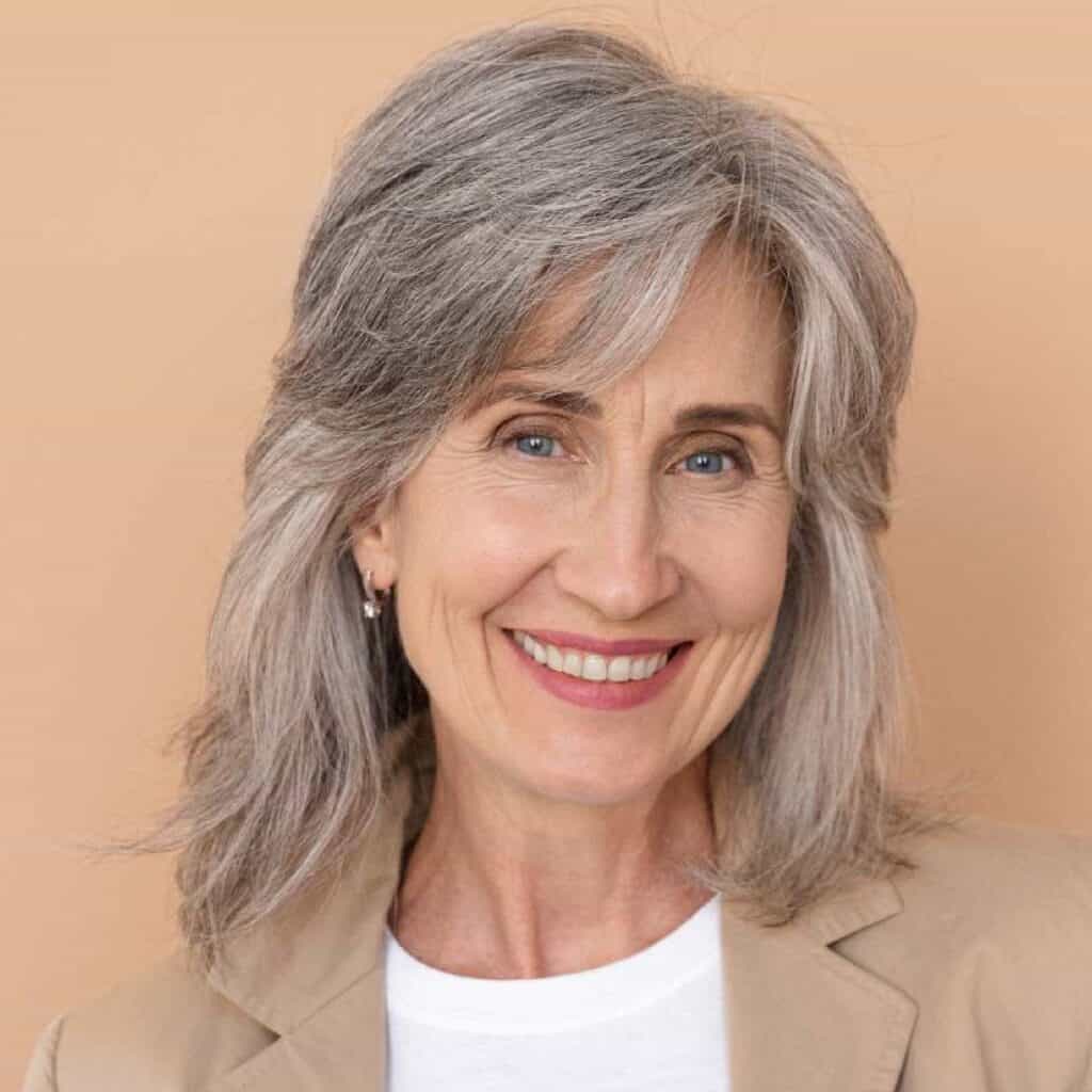 Reife Frau mit grauen Haaren ist am lächeln