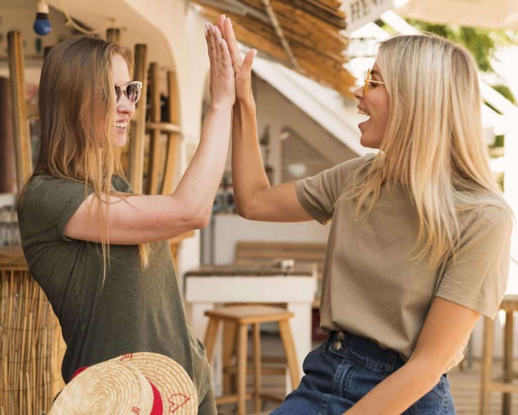 Zwei Frauen um die 30 geben sich ein High Five